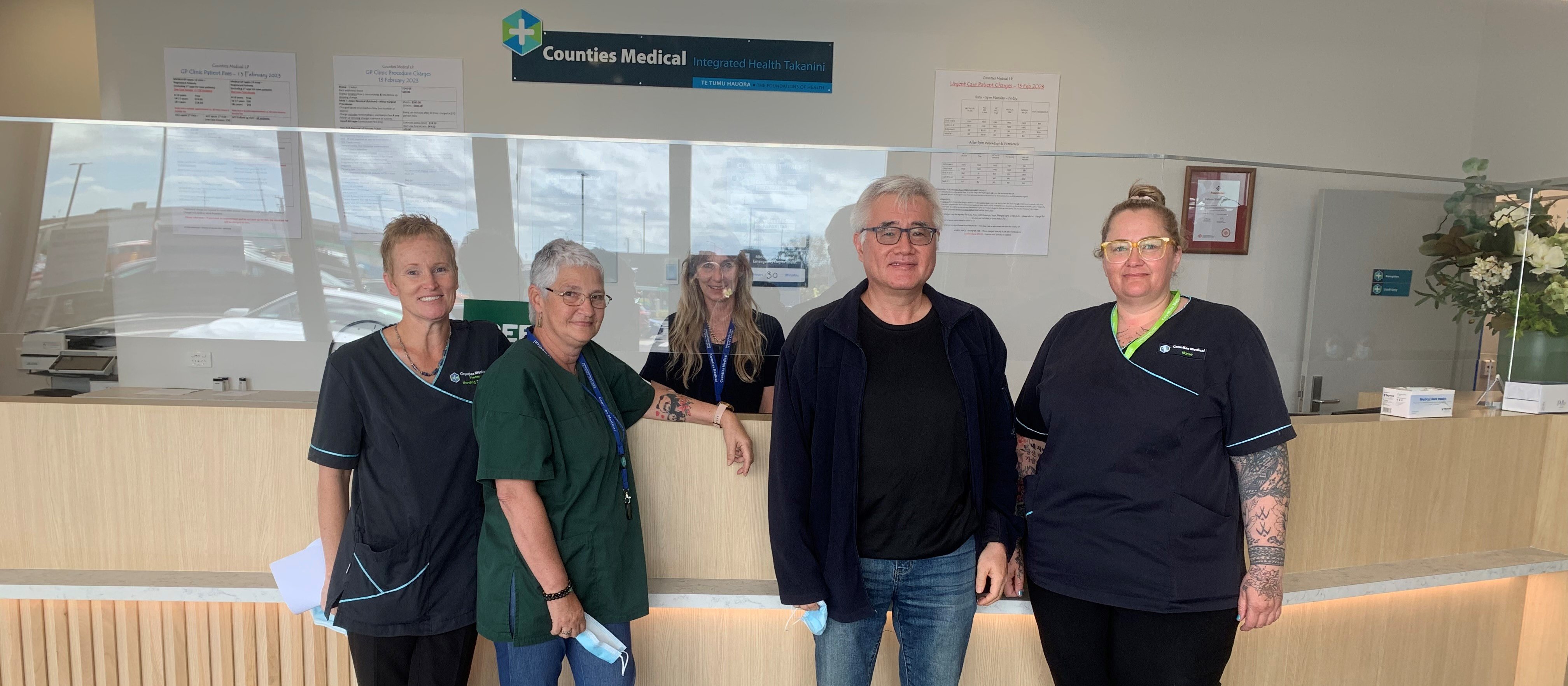 Image shows staff from Counties Medical Takanini standing in front of the reception desk