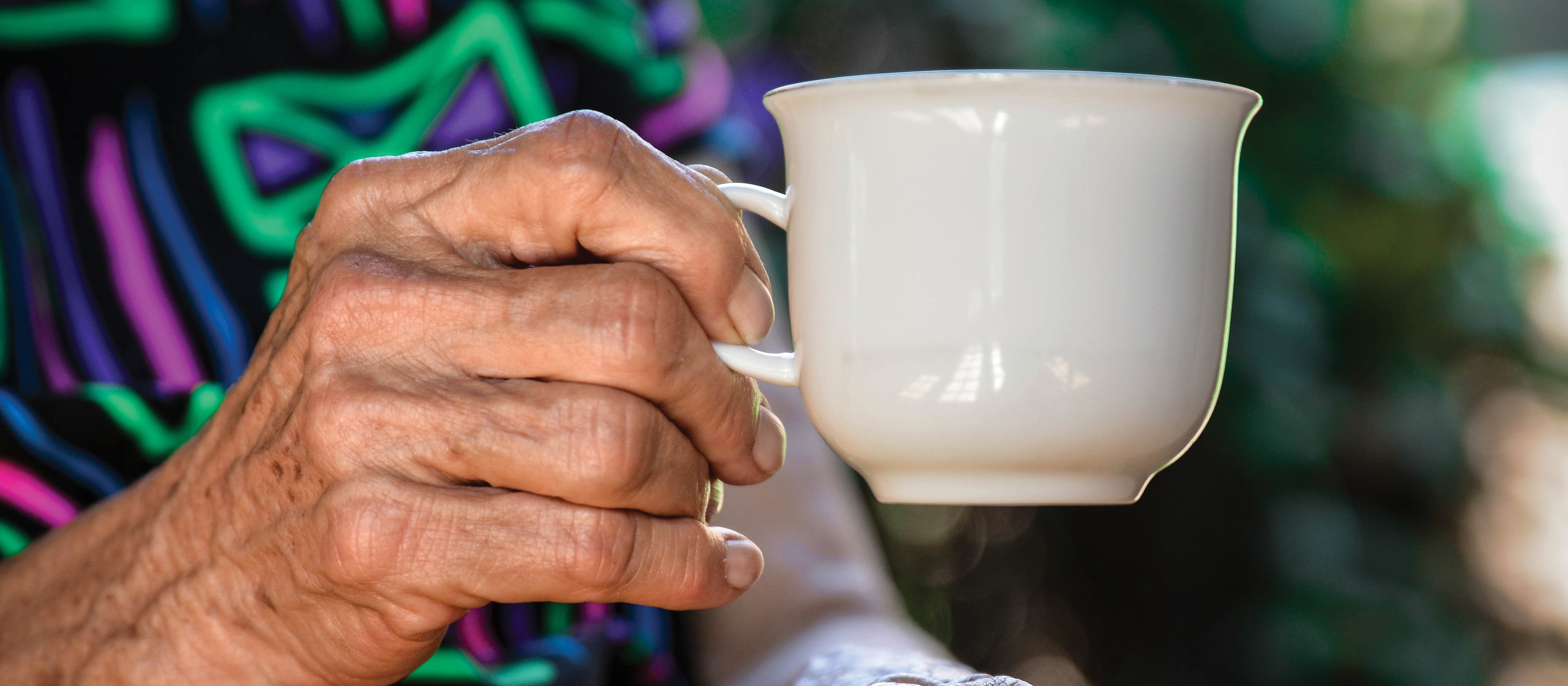 Elder hand holding mug