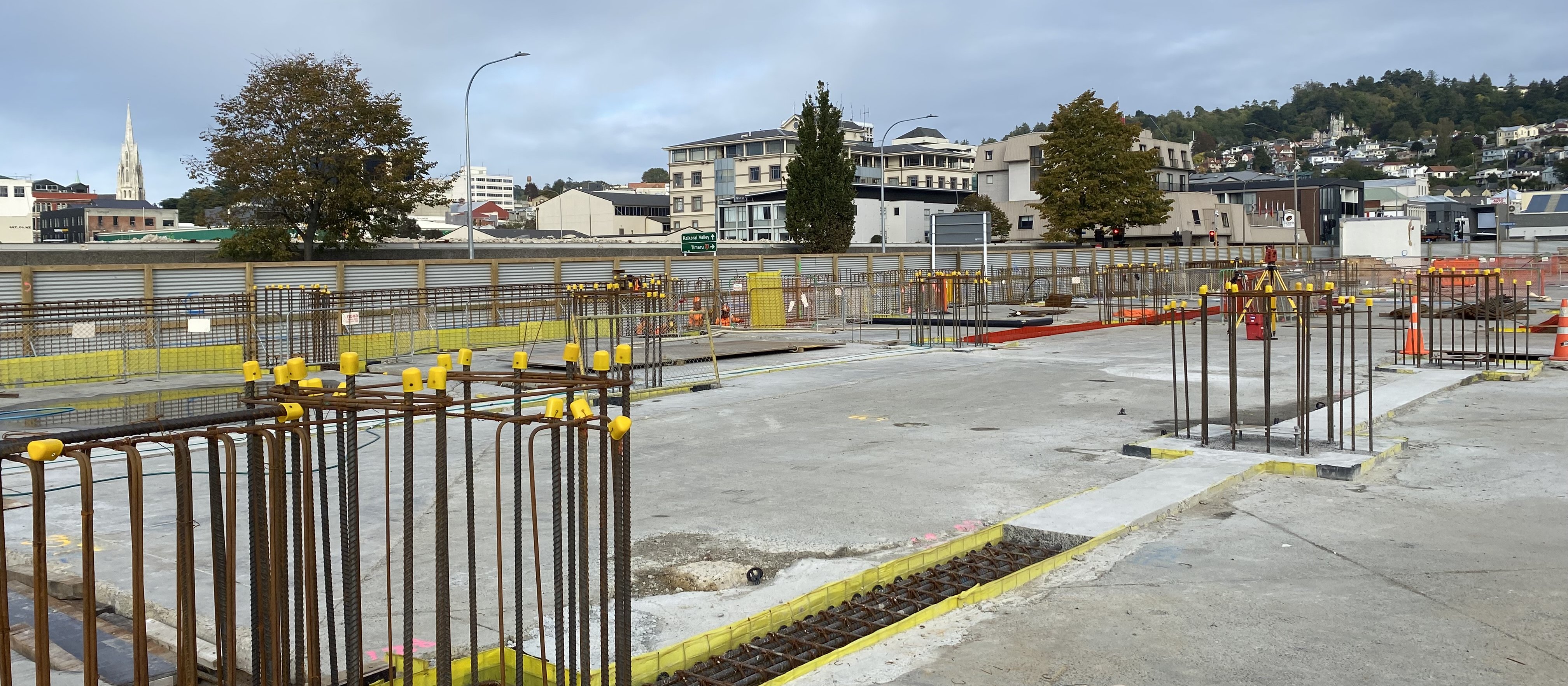 Foundation beams in various stages of construction. These link up the previously installed piles. The yellow material is leave-in-place boxing, and this retains the concrete until it hardens. In the bottom left corner the column alignment plate can be seen awaiting the columns, and these are due to arrive in June 2023