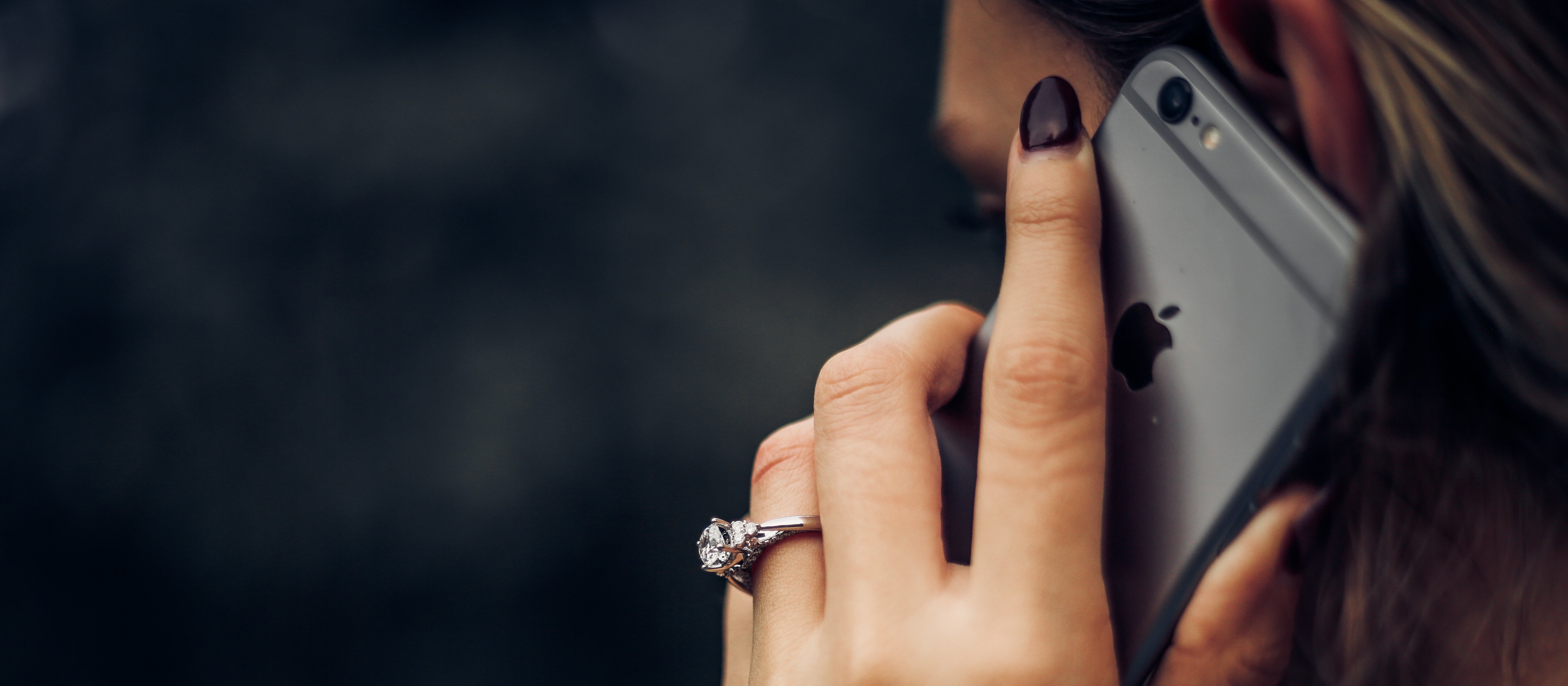 Close up of woman's hand holding an iPhone to her ear