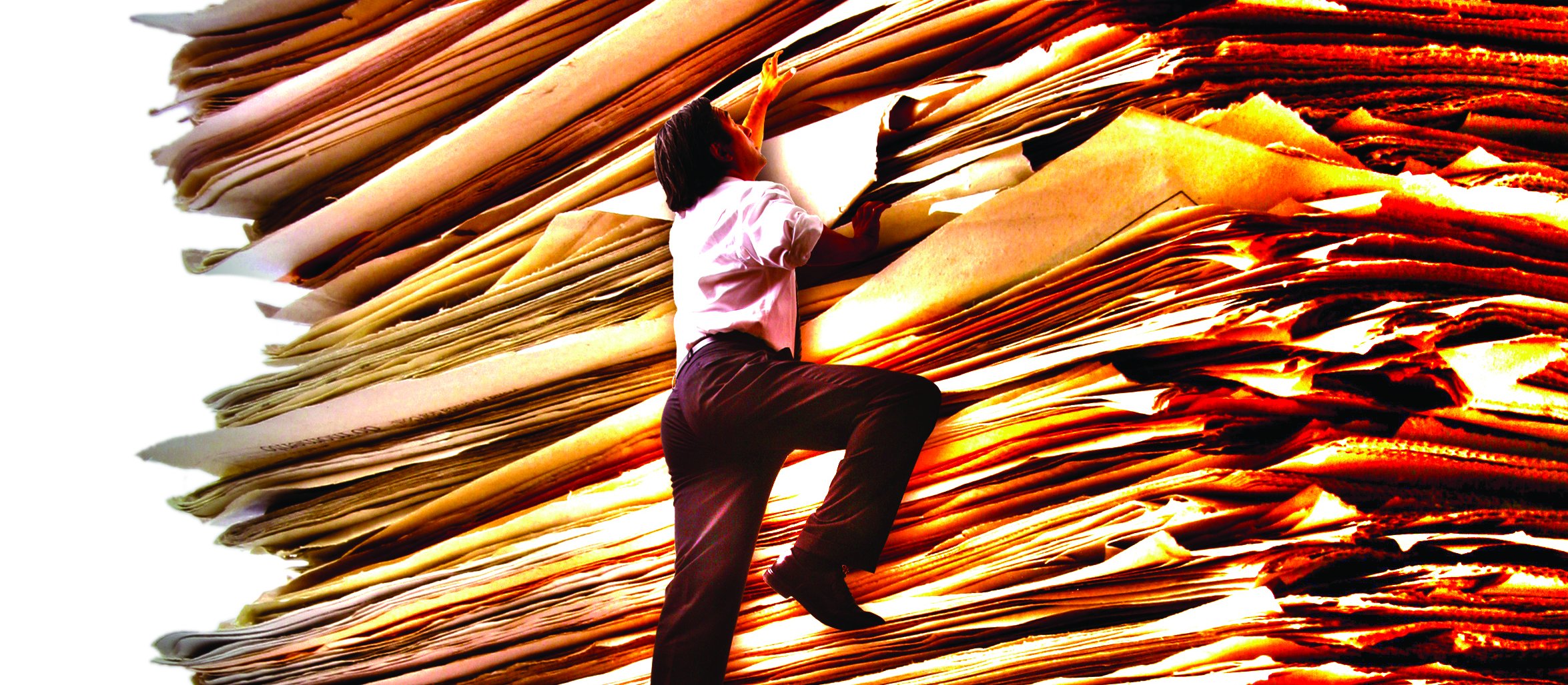 Man climbing paper stack [Image: Luis Portugal on iStock]