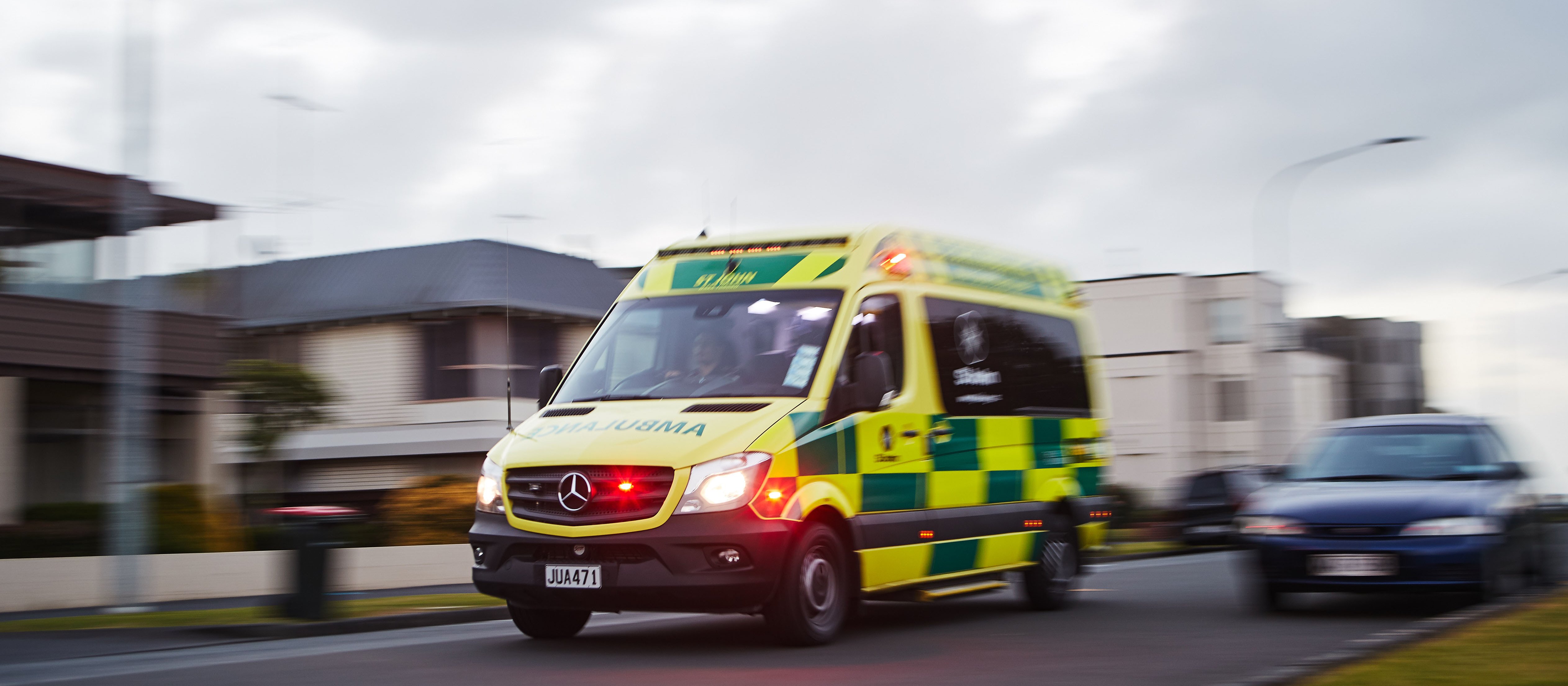 An ambulance with flashing lights appears to be driving fast to an emergency
