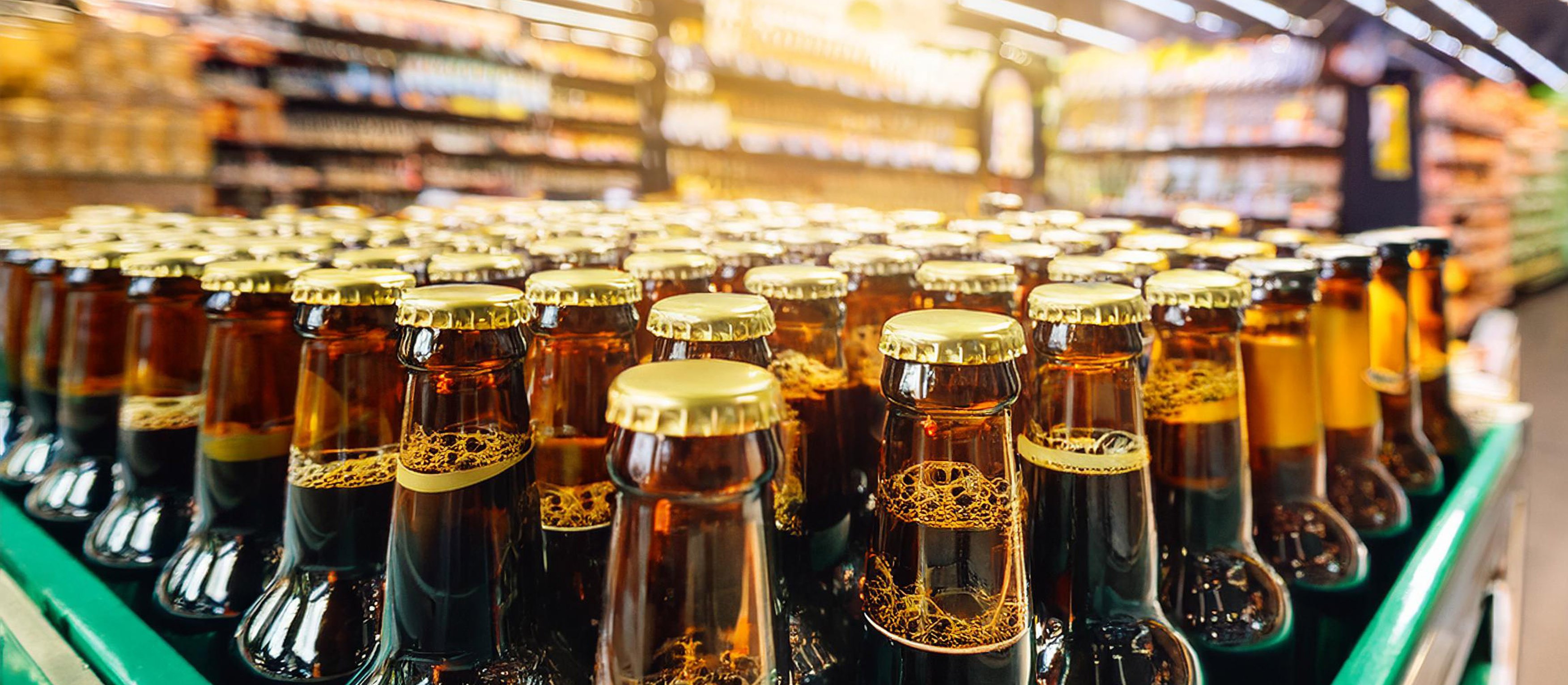 Crate of beer in foreground, with supermarket shelves in background