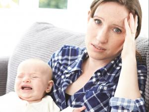 Harrassed young mother and baby