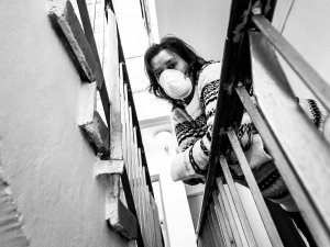 Woman wearing a mask on a balcony_Cold Snowstorm on iStock