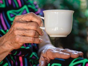 Elder hand holding mug 