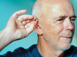 Man adjusting hearing aid