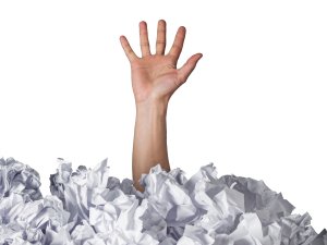 Hand drowning in paper CR artisteer on iStock