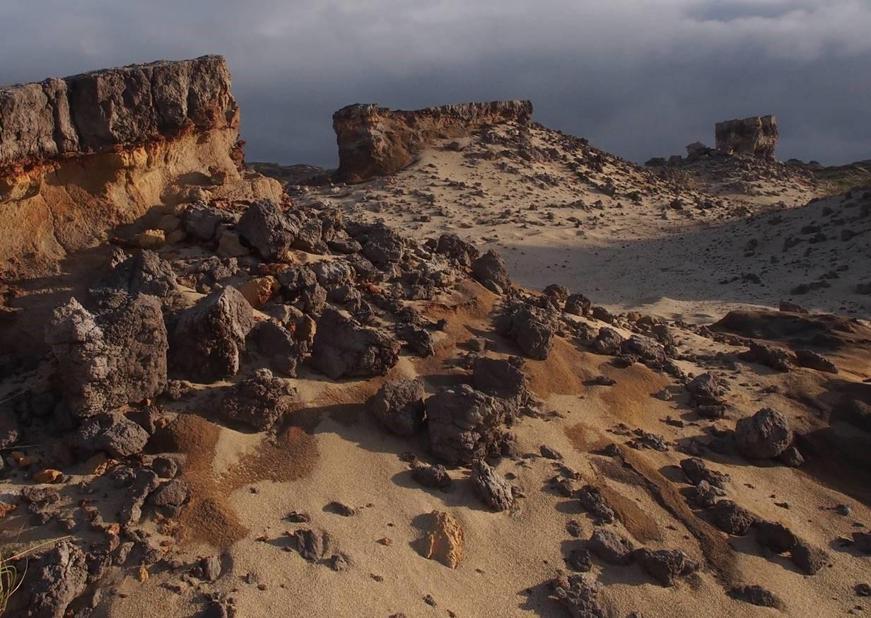Volcanic layered rocks among the sand dunes