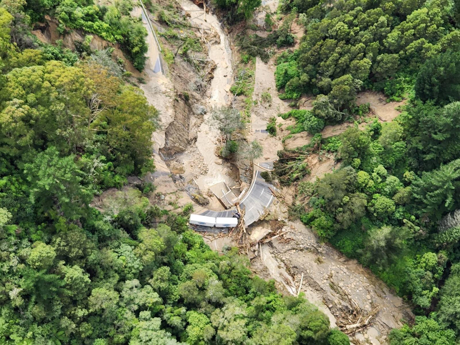 A truck trapped by floodwater and debris on a washed out part of SH2 caused by Cyclone Gabrielle