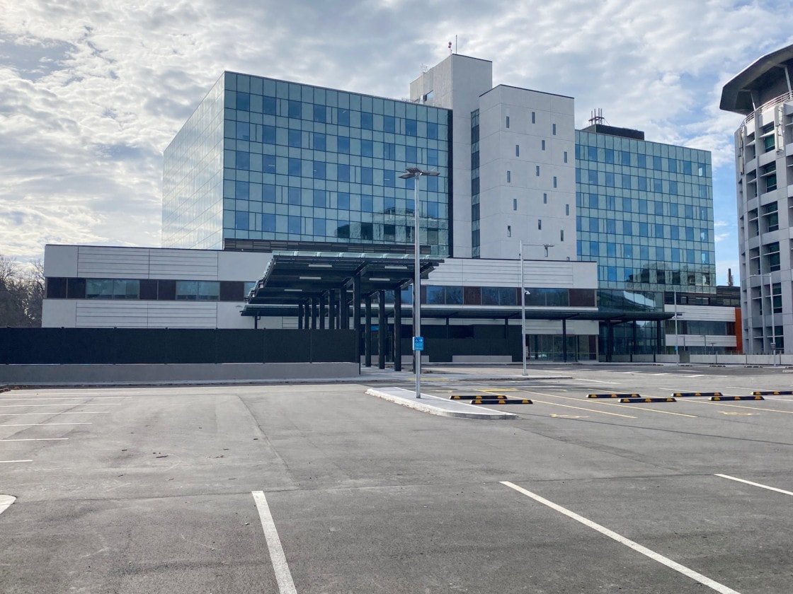 A large multi-story building overlooking a carpark on a cloudy day