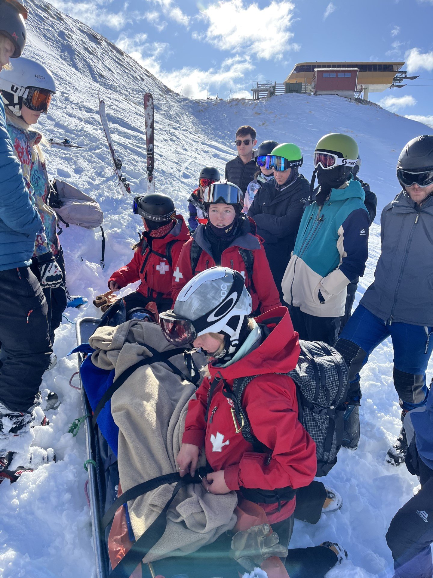 Image shows medical trainees practicing treating a patient on a snowy mountainside